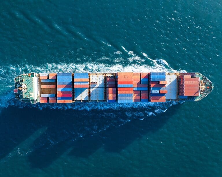 Aerial top view of cargo ship carrying containers