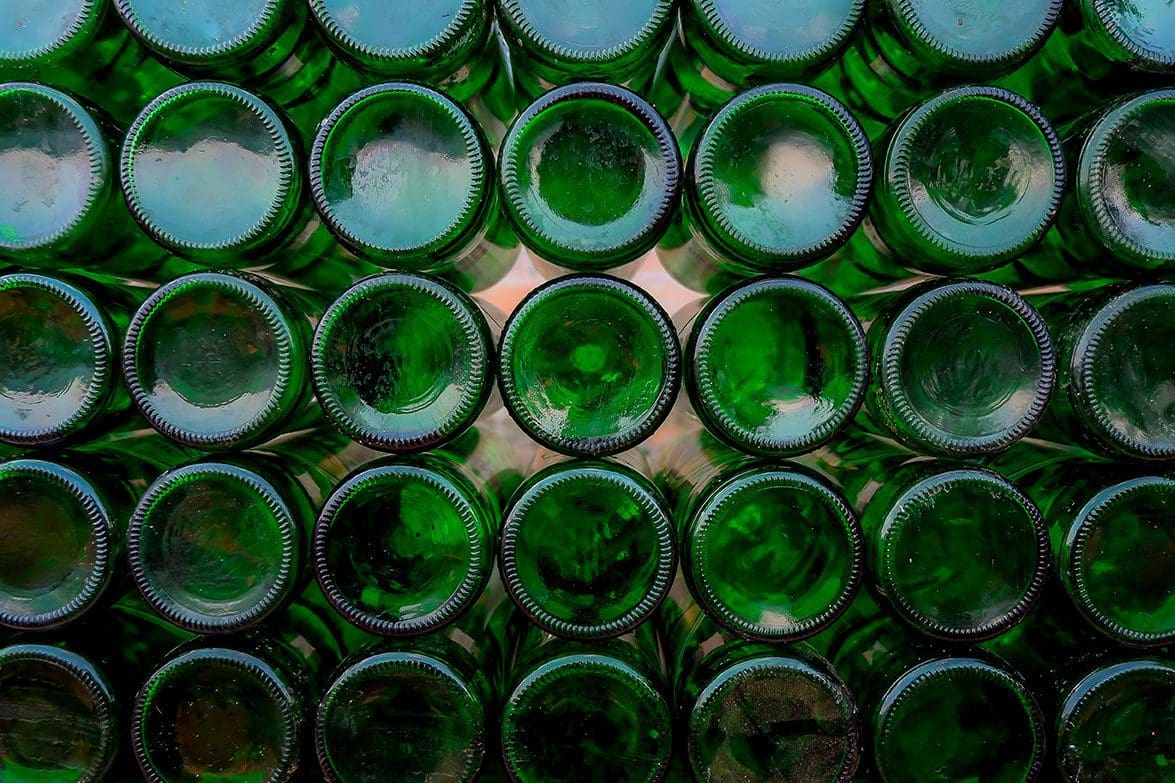 The bottom of stacked green bottles