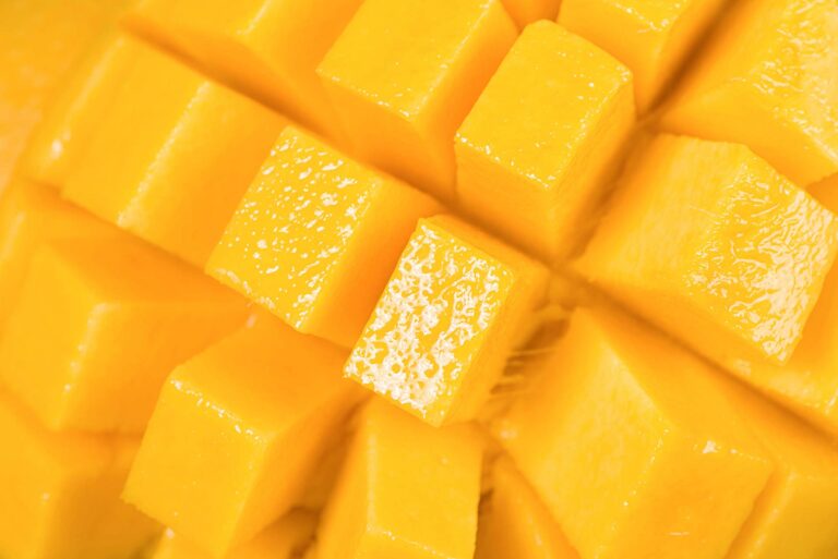 Close-up of freshly cut ripe mango cubes, showing vibrant yellow colour and juicy texture